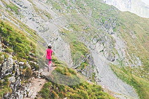 Little girl walking alone on a path on top of a mountain