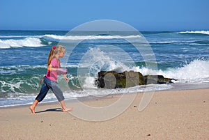 Little girl walking on beach