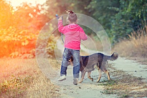 Little girl walking with dog on country road