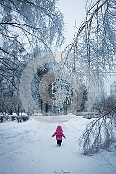 Little girl walking in the iced forest (Narnia)