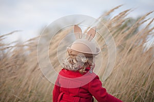 Little girl walking in the park, autumn day, windy weather.