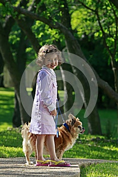 Little girl walking pet dog