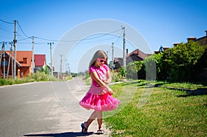 Little girl is walking on the road in the village