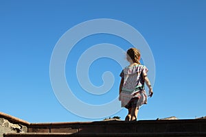 Little girl walking up the stairs with a kite in the sky