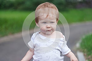 A little girl walks along the road and looks away