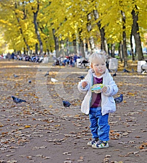 Little girl walks in gardens in fall