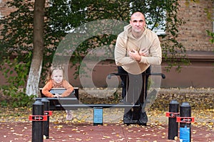 A little girl walks with her father on the playground. Healthy active family vacation concept