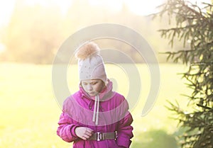 Little girl walks outdoors in sunny day. Early spring in countryside