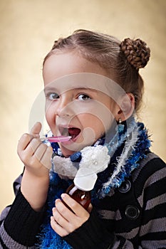 Little girl taking cough medicine syrup