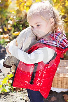 Little girl in warm clothes with toy rabbit