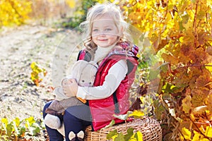 Little girl in warm clothes with toy rabbit