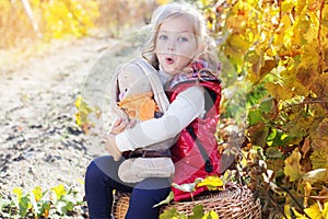Little girl in warm clothes with toy rabbit