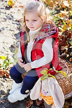 Little girl in warm clothes with toy rabbit