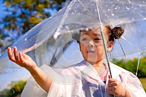 A little girl was happily standing in an umbrella against the rain