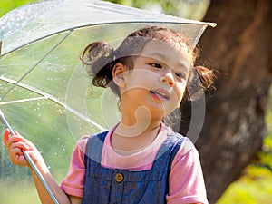 A little girl was happily standing in an umbrella against the rain