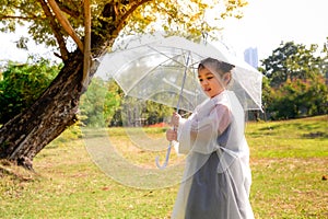 A little girl was happily standing in an umbrella against the rain