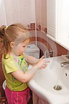 The little girl washes hands photo