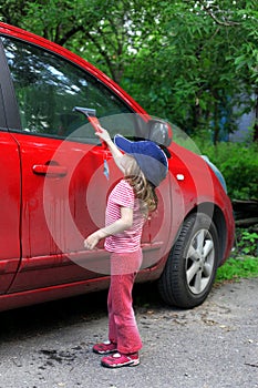 Little girl washing car