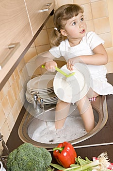 Little girl washing dishes