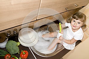 Little girl washing dishes