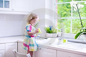 Little girl washing dishes