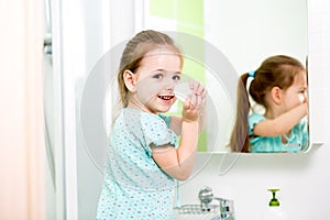 Little girl washing hands and showing soapy palms