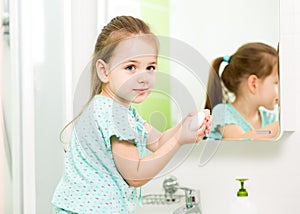 Little girl washing hands and showing soapy palms