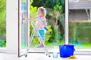 Little girl washing a window