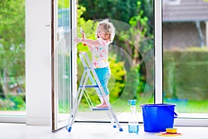 Little girl washing a window