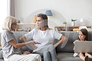 Small girl witness mother and grandmother arguing at home photo