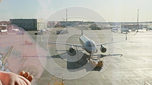 little girl watching Parked plane at the Moscow airport through the gate window. Maintenance and preparation of the