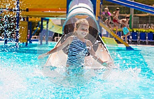 Little girl on water slide at aquapark during