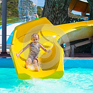 Little girl on water slide at aquapark during