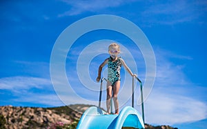 Little girl on water slide at aquapark on summer