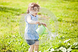 The little girl with the watering can in the garden