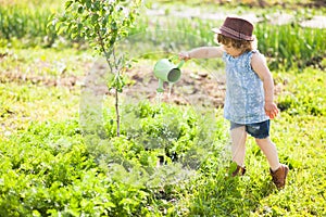 The little girl with the watering can in the garden