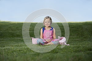 Little girl with watering can in the garden