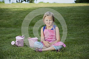 Little girl with watering can in the garden