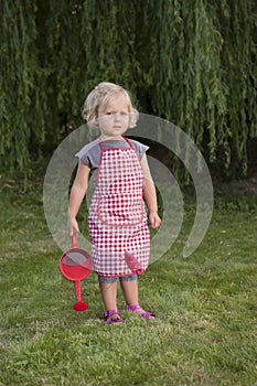 Little girl with watering can in the garden