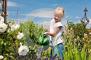 Little girl watering flowers