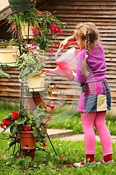 Little girl watering flowers