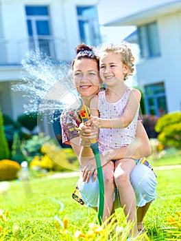 Little girl watering flowers