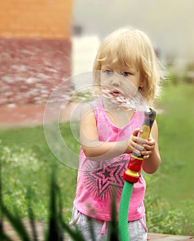 Little girl watering plants