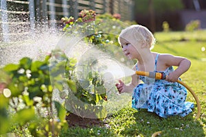 Little girl watering plants in the garden