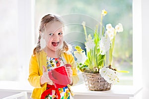 Little girl watering spring flowers