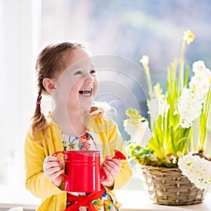 Little girl watering spring flowers