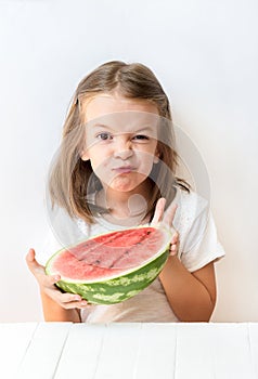 A little girl is a watermelon, croaks, laughs, humor, emotions, eat watermelon