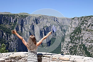 Little girl waves with a Greek flag on Vikos gorge Zagoria