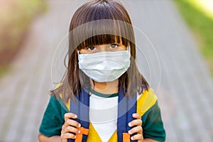Little girl wearing anti virus mask going to school