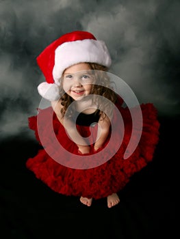 Little girl wearing Christmas santa hat and skirt